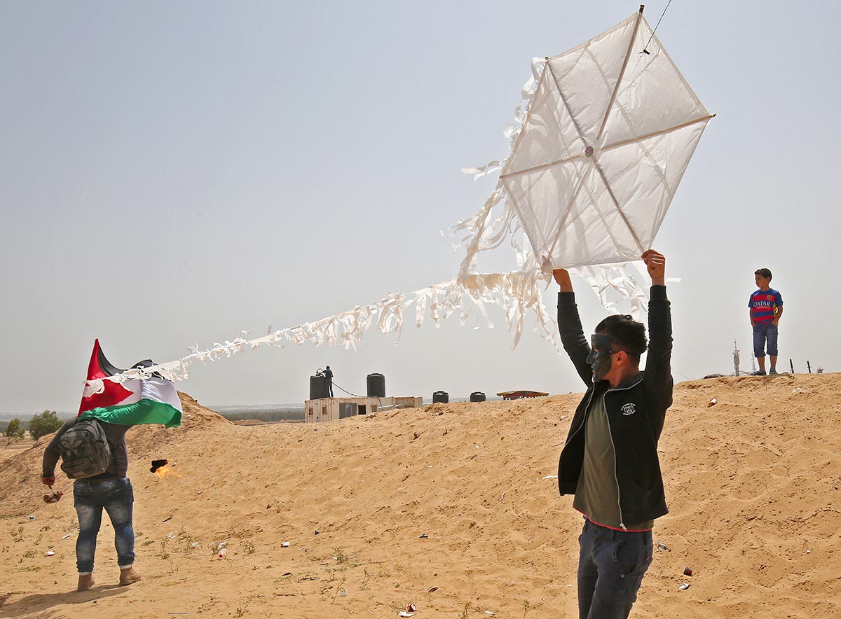 Palestinian activists attach a firebomb to a kite (Gaza Strip)