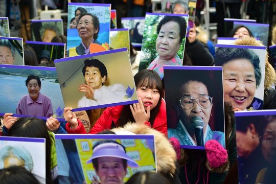 South Korean hold portraits of former "comfort women", who were forced into wartime sexual slavery for Japanese soldiers