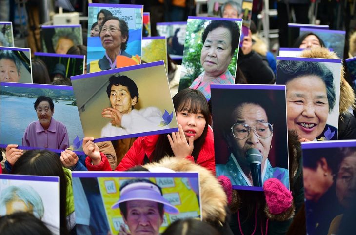 South Korean hold portraits of former "comfort women", who were forced into wartime sexual slavery for Japanese soldiers