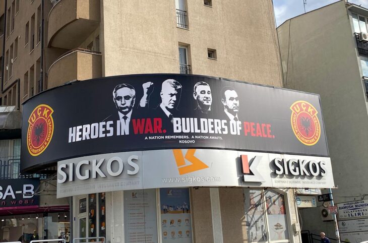 Au Kosovo, 4 ex-membres de l'Armée de libération du Kosovo (UCK), condamnés à La Haye pour des crimes de guerre, sont célébrés dans une bannière affichée en pleine rue à Pristina. Photo : une bannière montrant les 4 visages des « héros de guerre » et « artisans de la paix » est accrochée sur la façade d'un immeuble.