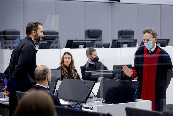 Salih Mustafa's lawyer (Julius von Bone) faces and greets prosecutor Jack Smith during the trial in The Hague for the allegated war crimes commited by Mustafa in Kosovo.