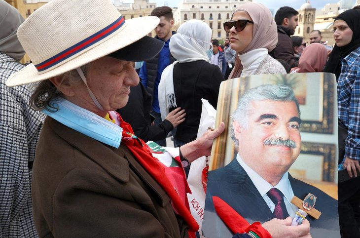 Un homme tient dans ses mains une photo de Rafiq Hariri