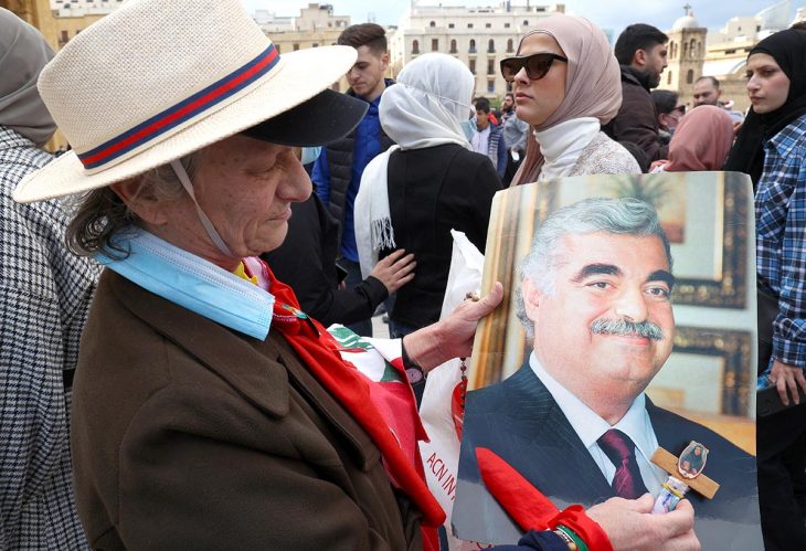 Un homme tient dans ses mains une photo de Rafiq Hariri