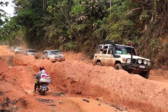 A Finnish court crosses Liberia in a 4x4 convoy along muddy tracks.