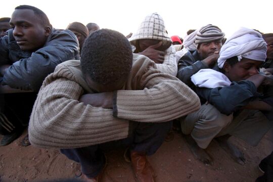 Procès d'Amanuel Walid aux Pays-Bas pour trafic d'êtres humains en Libye. Photo : des migrants africains sont assis et serrés par terre dans un camp de détention à Kufra, en Libye.