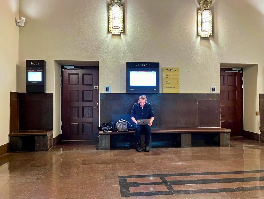Martin Schibbye est journaliste, un des rares à couvrir le procès Lundin, en Suède. Photo : Schibbye est seul devant l'entrée de la salle d'audience 34 à Stockholm.