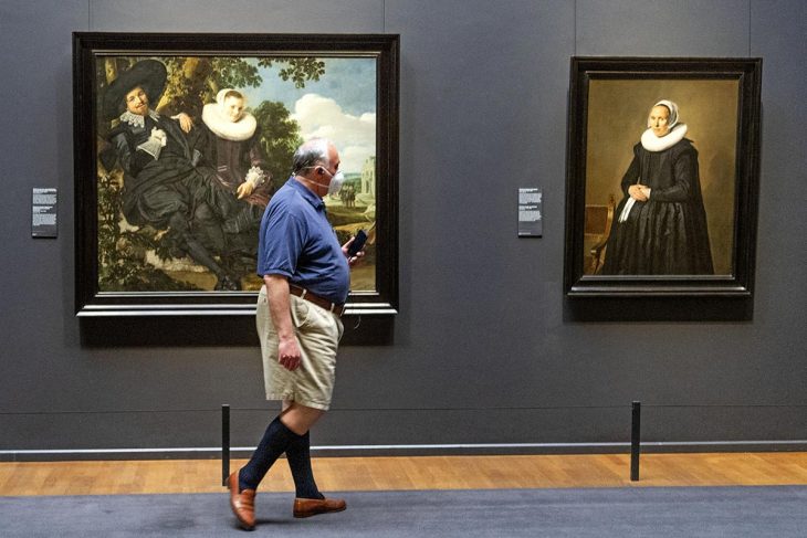 Un homme marche devant des oeuvres d'art exposées au Rijksmuseum d'Amsterdam (Pays-Bas)