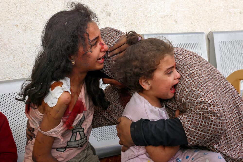 Enquête de la CPI en Palestine : en attendant les résultats hypothétiques de l'enquête de la Cour pénale internationale, le bilan des victimes s'alourdit en Palestine (et en Israël). Photo : une femme palestinienne prend ses enfants blessés dans ses bras.