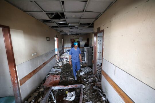 Bombing hospitals and International Humanitarian Law (IHL) - Photo : Hospital staff walk in the corridor of a hospital destroyed by an Israeli missile shell, in the Gaza Strip (Palestine).