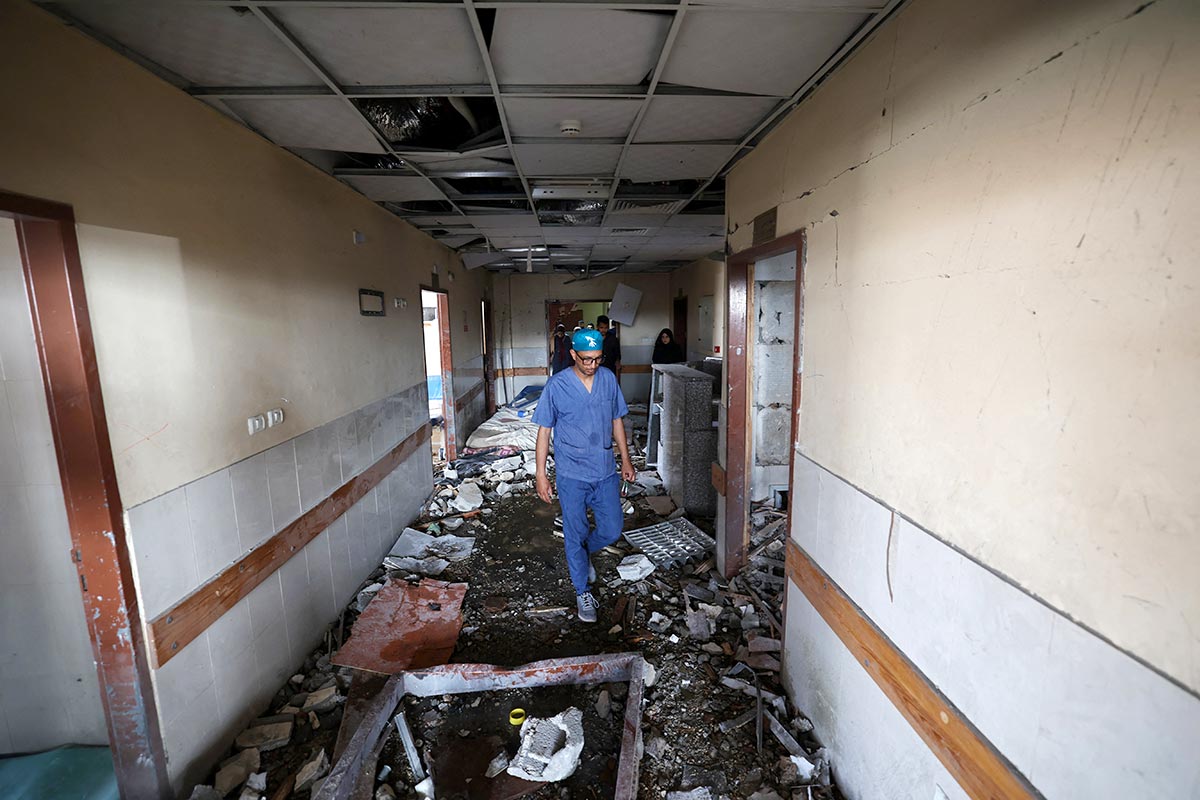 Bombing hospitals and International Humanitarian Law (IHL) - Photo : Hospital staff walk in the corridor of a hospital destroyed by an Israeli missile shell, in the Gaza Strip (Palestine).