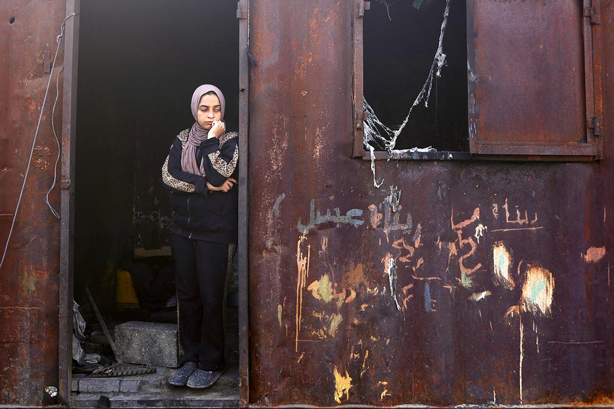 Une jeune Palestinienne se tient près du site d'une frappe israélienne sur un campement abritant des personnes déplacées à Gaza.