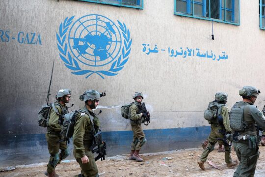 Foreign soldiers and soldiers with dual nationality serving in the Israeli army are accused of war crimes in Gaza. Photo: Israeli soldiers patrol a street in Gaza City, passing a wall on which is painted a UN logo and an inscription in Arabic.