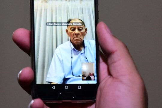 Eusebio Torres participant par liaison vidéo à la reconstitution des crimes pour lesquels il a été condamné, le 20 février, à 30 ans de prison, au Paraguay. Photo : quelqu'un tient un smartphone diffusant une vidéo d'Eusebio Torres.