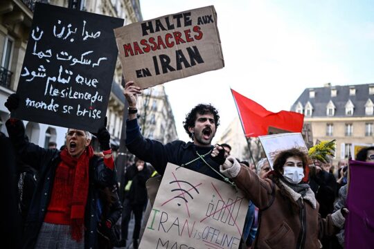 A protester holds a placard reading 