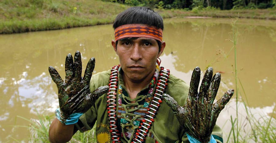 Elmer Hualinga, a Quechua environmental monitor from Fediquep with oil in his hands from a spill.