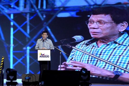 Rodrigo Duterte, former president of the Philippines, is on trial before the International Criminal Court (ICC) in The Hague. Photo : Duterte delivers a speech while he's displayed on a large screen behind him.
