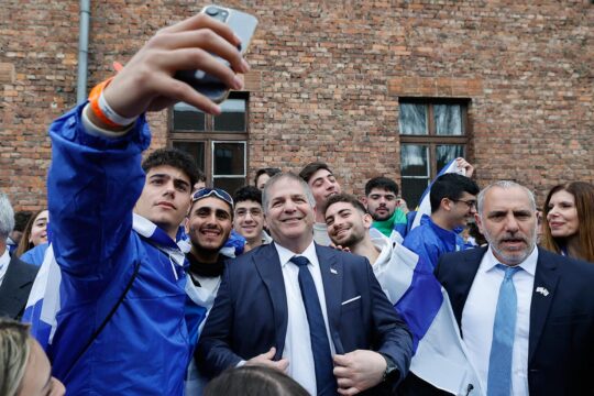 Yoav Kisch (ministre de l’Éducation en Israël), pose pour des selfies avec des étudiants portant des drapeaux israéliens, dans l’ancien camp d’extermination nazi d’Auschwitz-Birkenau en Pologne.