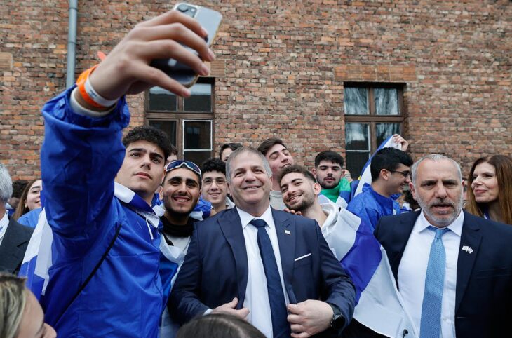 Yoav Kisch (ministre de l’Éducation en Israël), pose pour des selfies avec des étudiants portant des drapeaux israéliens, dans l’ancien camp d’extermination nazi d’Auschwitz-Birkenau en Pologne.