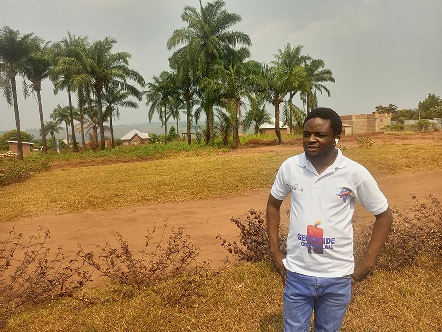 Emery Ngoy, a former employee of Fonarev, is wearing a T-shirt bearing the words ‘Congolese genocide’ next to a candle.