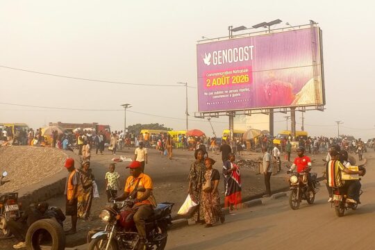 On a street in Kinshasa, in the Democratic Republic of the Congo (DRC), a large advertising hoarding displays a message about ‘Genocost’, announcing a ‘national commemoration on 2 August 2026’.