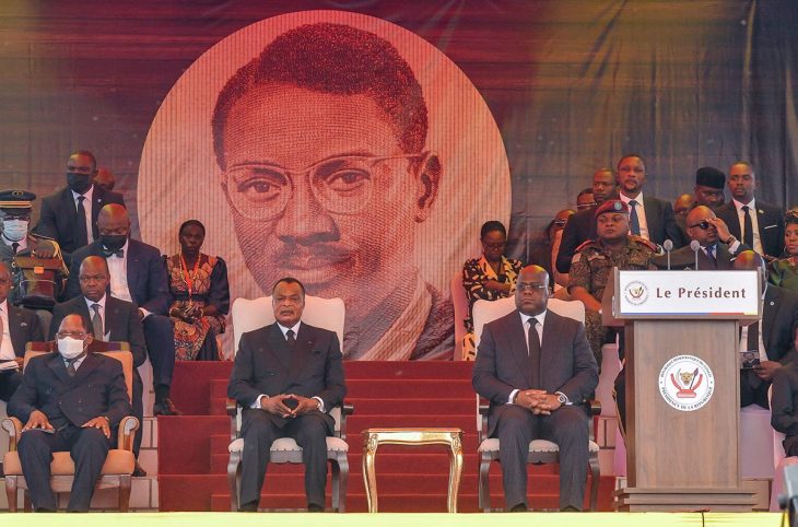 Felix Tshisekedi and Denis Sassou Nguesso (foreground) attend the funeral ceremony of Patrice Lumumba (large portrait in background).