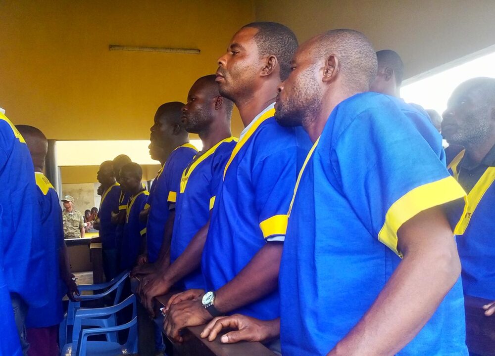 En république démocratique du Congo (RDC) des jugements ont été rendus dans le procès des massacres de Yumbi. Photo : des accusés, en chemises bleu et jaune, se tiennent debout lors de l'audience.