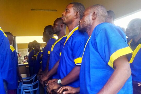 En république démocratique du Congo (RDC) des jugements ont été rendus dans le procès des massacres de Yumbi. Photo : des accusés, en chemises bleu et jaune, se tiennent debout lors de l'audience.
