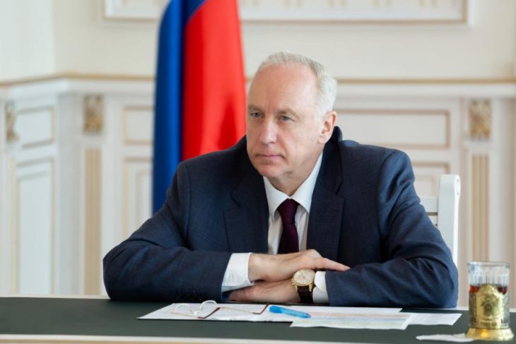 Alexander Bastrykin poses in front of a Russian flag