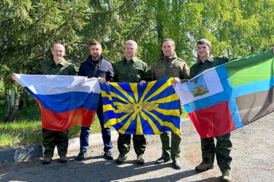 Prisonniers de guerre russes échangés contre des prisonniers de guerre ukrainiens - Photo : soldats russes tenant des drapeaux.