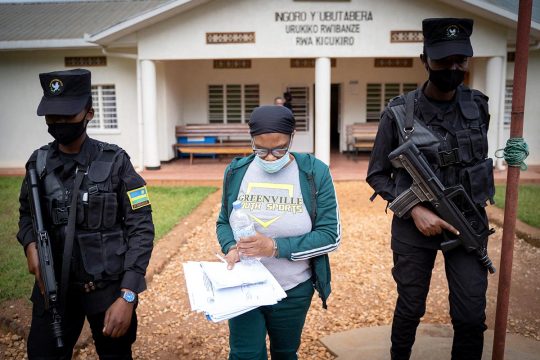 Béatrice Munyenyzezi escorted by police officers in Kigali