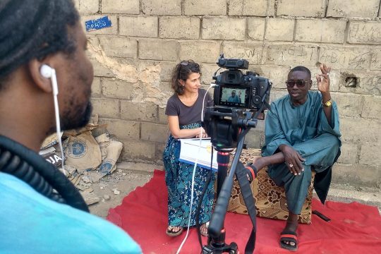 Harouna Daouda Dia is interviewed at his home by 2 people