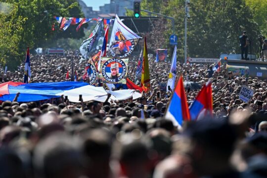 Funérailles de Ratko Mladic à Belgrade (Serbie). Photo : des milliers de Serbes défilent dans une rue de Belgrade en brandissant des drapeaux serbes et des portraits de Mladic.