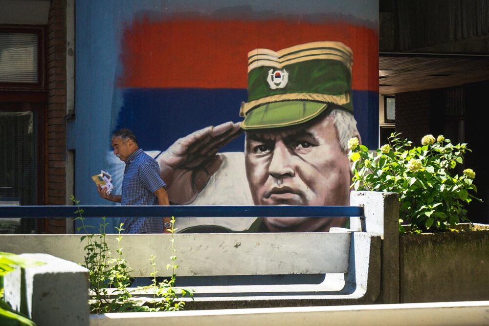 In Serbia, denial of the Srebrenica genocide could lead to a new conflict. Photo: A person walks past a mural depicting the former military leader of the Bosnian Serbs, Ratko Mladic, in a street in Belgrade, Serbia.