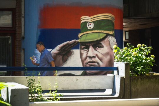 In Serbia, denial of the Srebrenica genocide could lead to a new conflict. Photo: A person walks past a mural depicting the former military leader of the Bosnian Serbs, Ratko Mladic, in a street in Belgrade, Serbia.
