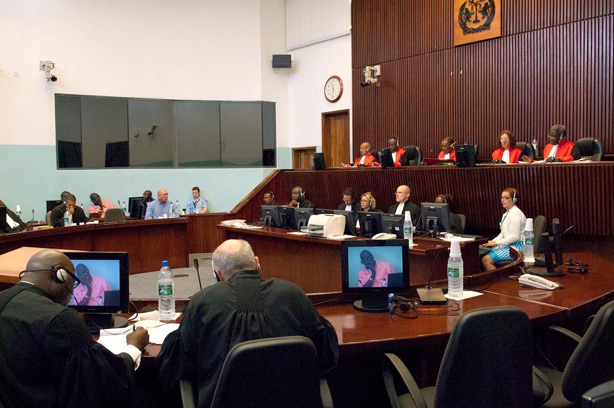 Sur le banc en-dessous des juges, assistants juridiques, greffiers et huissiers écoutent un témoin devant le Tribunal spécial pour la Sierra Léone