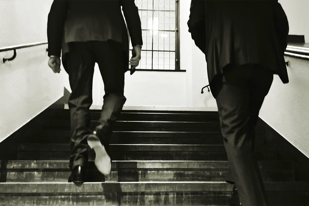 Lundin trial in Sweden over war crimes committed in South Sudan. Photo: Ian Lundin and Alexandre Schneiter, the two co-defendants, are seen from behind as they climb the steps of the courthouse.