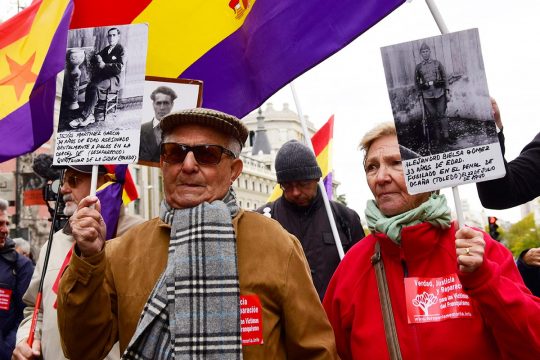 2 elderly people demonstrate (holding up pictures of Franco's victims), in the streets of Madrid (Spain)