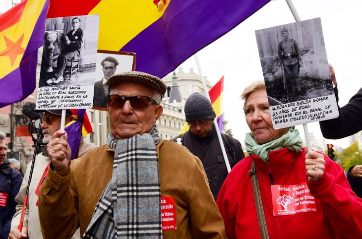 2 elderly people demonstrate (holding up pictures of Franco's victims), in the streets of Madrid (Spain)