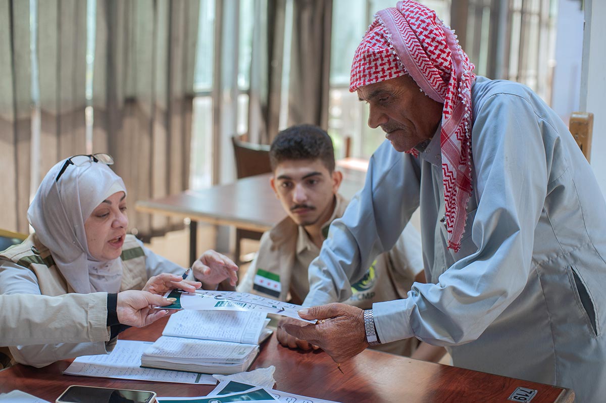 Abu Naim, un agriculteur peu habitué aux smartphones, argumente avec une employée de la Commission nationale pour les personnes disparues en Syrie, alors qu’elle tente de lui expliquer comment s’inscrire sur la plateforme Athar.