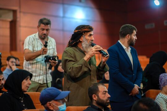 En Syrie, la Commission nationale pour les personnes disparues propose de l'aide aux proches des victimes du régime de Bachar al-Assad. Photo : le père d'une victime s'exprime (via un micro) dans un amphithéâtre mis à disposition par la faculté d'Alep.