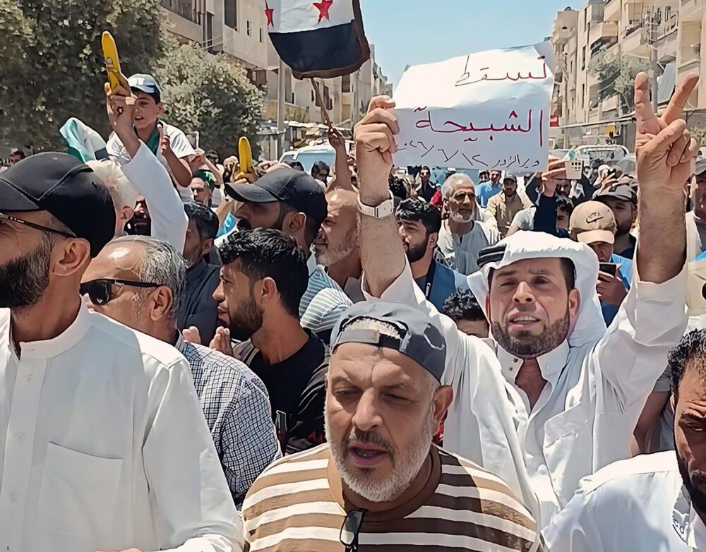A Deir ez-Zor, en Syrie, des manifestations ont lieu pour soutenir le processus de justice transitionnelle qui n'avance pas malgré les engagements du gouvernement. Photo : des gens manifestent dans la rue en brandissant des drapeaux syriens et des bananes (symbole de justice).