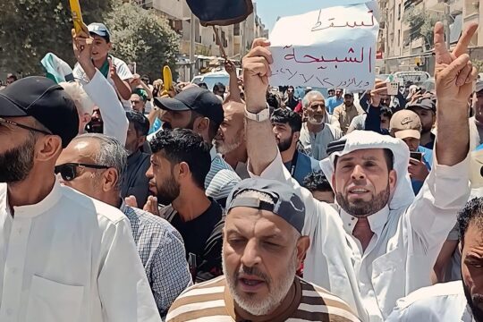 A Deir ez-Zor, en Syrie, des manifestations ont lieu pour soutenir le processus de justice transitionnelle qui n'avance pas malgré les engagements du gouvernement. Photo : des gens manifestent dans la rue en brandissant des drapeaux syriens et des bananes (symbole de justice).