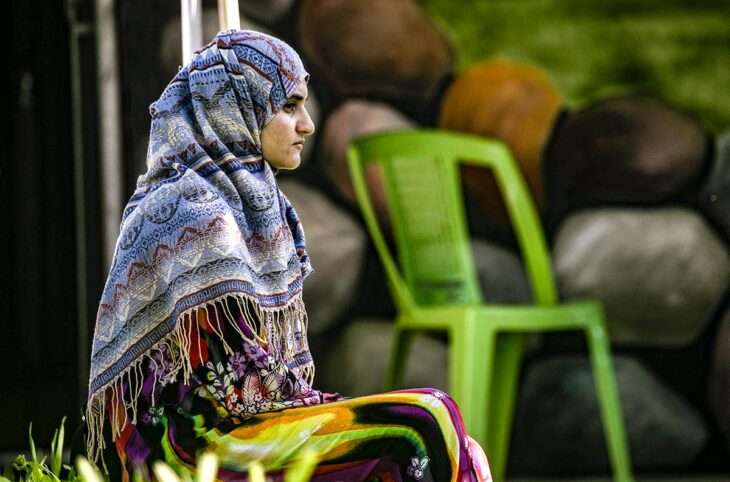 Génocide des Yézidis en Syrie : un procès démarre en France. Photo : une femme Yézidie est assise, le regarde dans le vague.