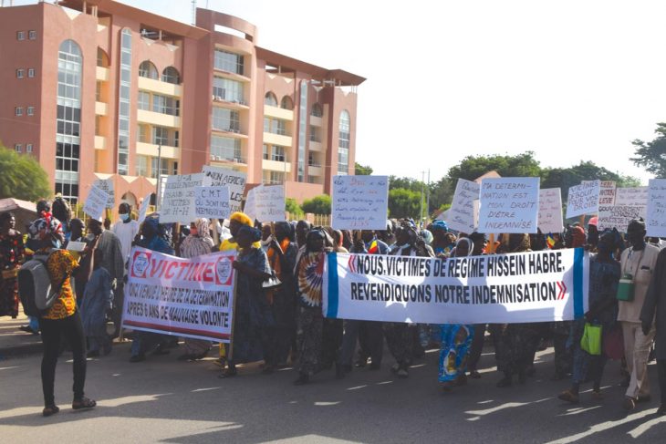 Demonstrators march in the street carrying a banner 