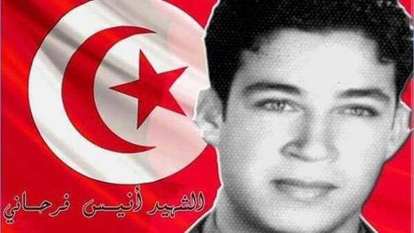 Anis Farhani next to a tunisian flag
