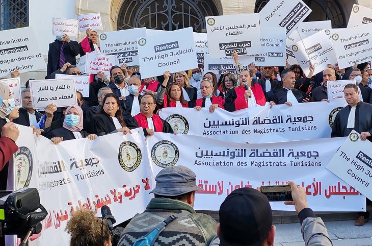 Des magistrats et avocats tiennent des pancartes et banderolles sur lesquelles on peut lire " Association des magistrats Tunisiens" et "Restore the high judicial council"