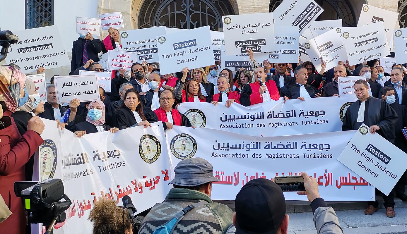 Des magistrats et avocats tiennent des pancartes et banderolles sur lesquelles on peut lire 