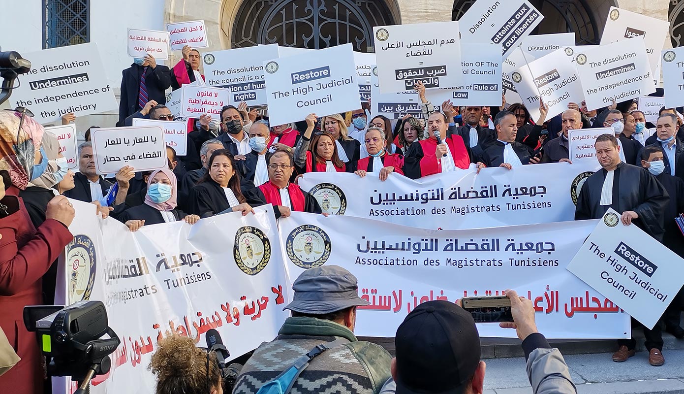 Des magistrats et avocats tiennent des pancartes et banderolles sur lesquelles on peut lire " Association des magistrats Tunisiens" et "Restore the high judicial council"