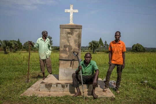 Kony trial in The Hague (ICC) - Photo: 3 residents gather near the memorial to the Lukodi massacre in Uganda.