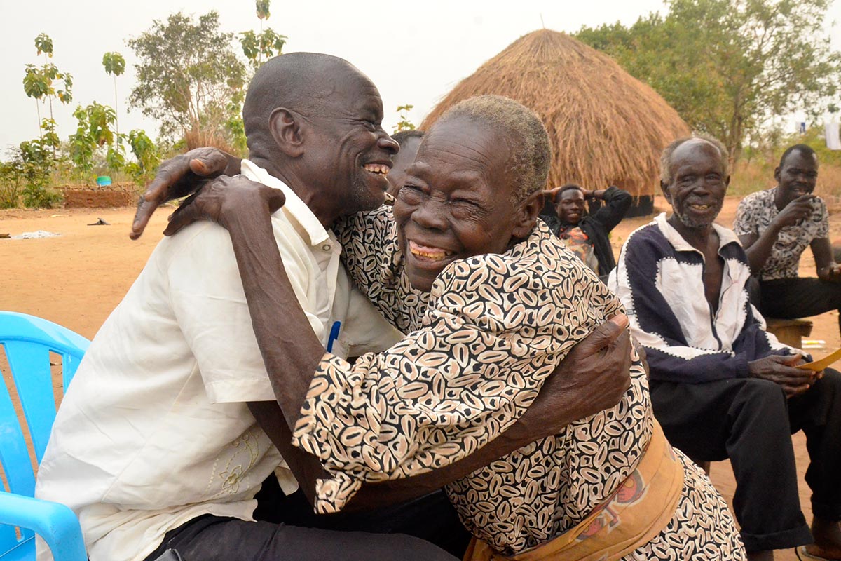 La mère de Thomas Kwoyelo embrasse un parent perdu de vue depuis longtemps, dans son village natal (Ouganda).